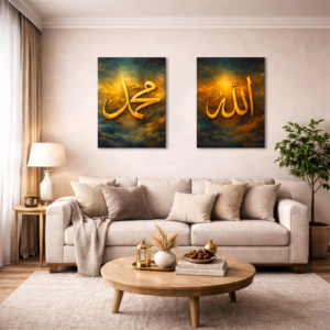 A cozy living room with a beige sofa and round wooden coffee table, decorated in neutral tones. Two framed artworks with gold Arabic calligraphy hang above the sofa—one reading “Muhammad” and the other “Allah”—set against dark, textured backgrounds. A table lamp, indoor plant, and soft furnishings create a warm, calm atmosphere.